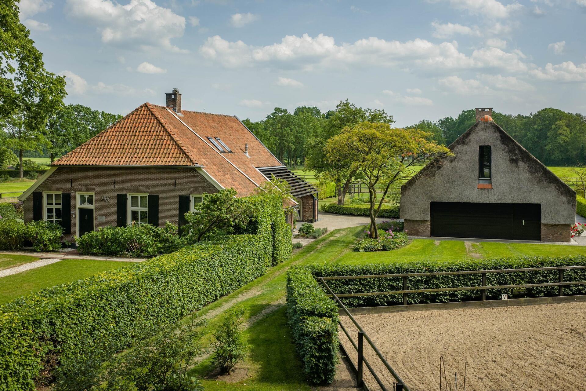 Woonboerderij Erve Nieuwkamp in Barchem, met rieten schuur en paardenbak in het Achterhoekse coulisselandschap